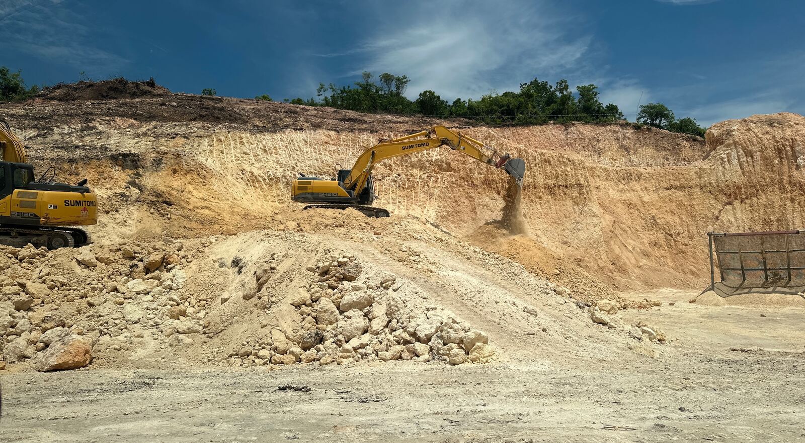 Excavator working a limestone quarry face